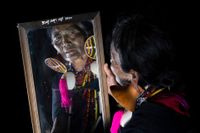 Vrouw van de Chin stam kijkt in de spiegel